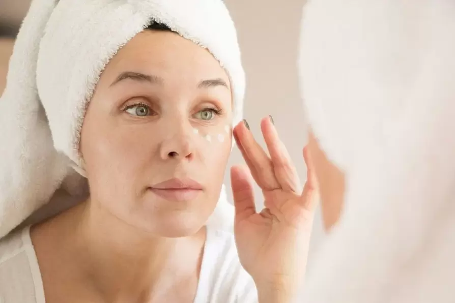 aplicando creme anti-rugas sob os olhos